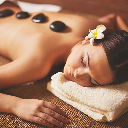 mulher em sessão de Massagem com Pedras Quentes