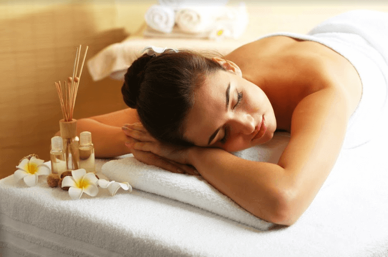 conceito de wellness mulher deitada em uma maca de massagem com toalha nas costas
