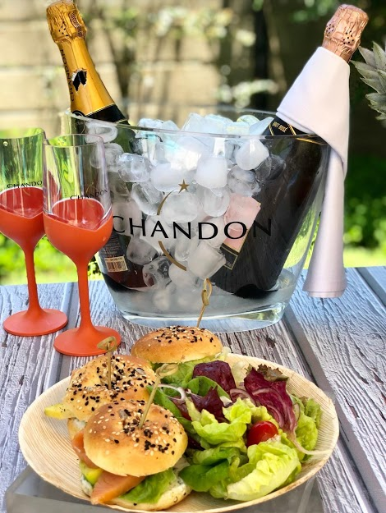 day use sp garrafas de chandon dentro de um balde de gelo com taças ao lado e uma refeição