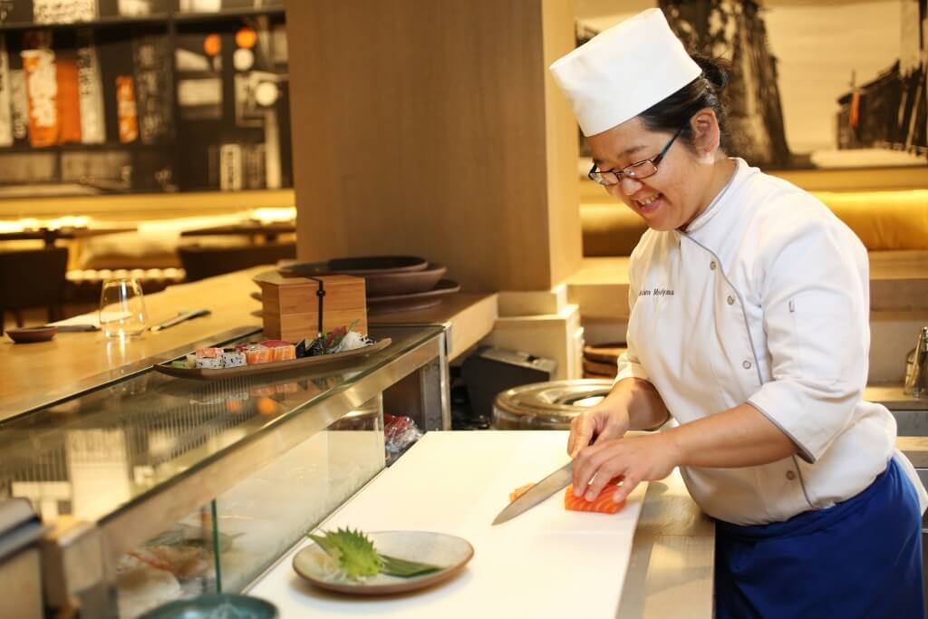 Mulher sushiwoman preparando prato de comida japonesa