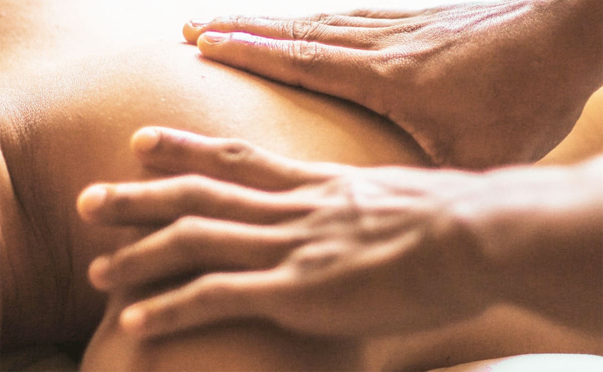 mãos massageando região das costas de outra pessoa demonstrando o que é drenagem linfática