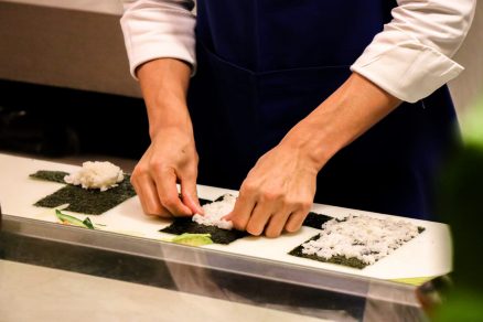 mãos de um sushiman preparando pratos como omakase