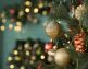 Enfeites na árvore de Natal cercada por luzes festivas.